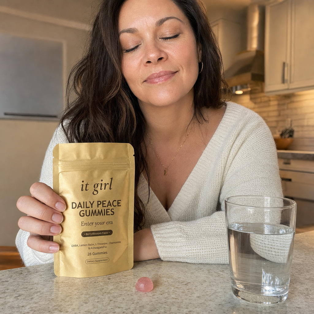 Woman in her forties at her early-evening kitchen counter resting her hand on the gold Daily Peace pouch and taking a calm exhale, the studied dose finally doing the quiet work