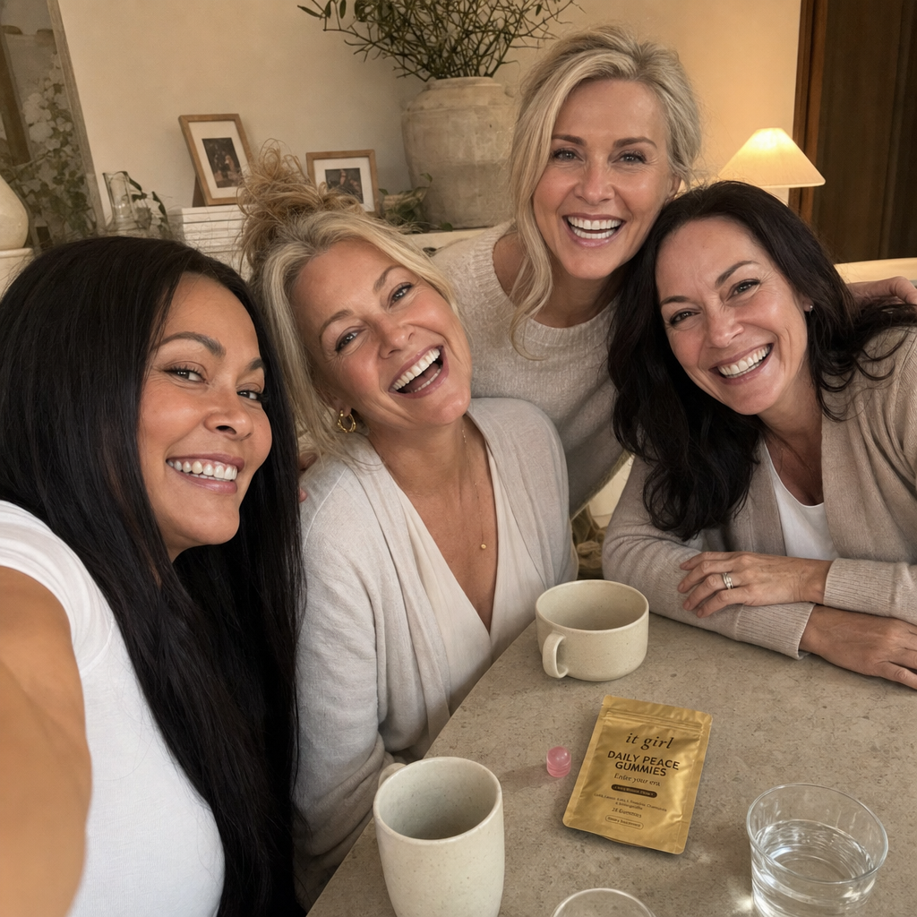 Group selfie of women in their forties and fifties laughing and all looking into the camera in a warm living room, a small gold Daily Peace pouch resting on the table, the readers who stopped buying the underdosed jars