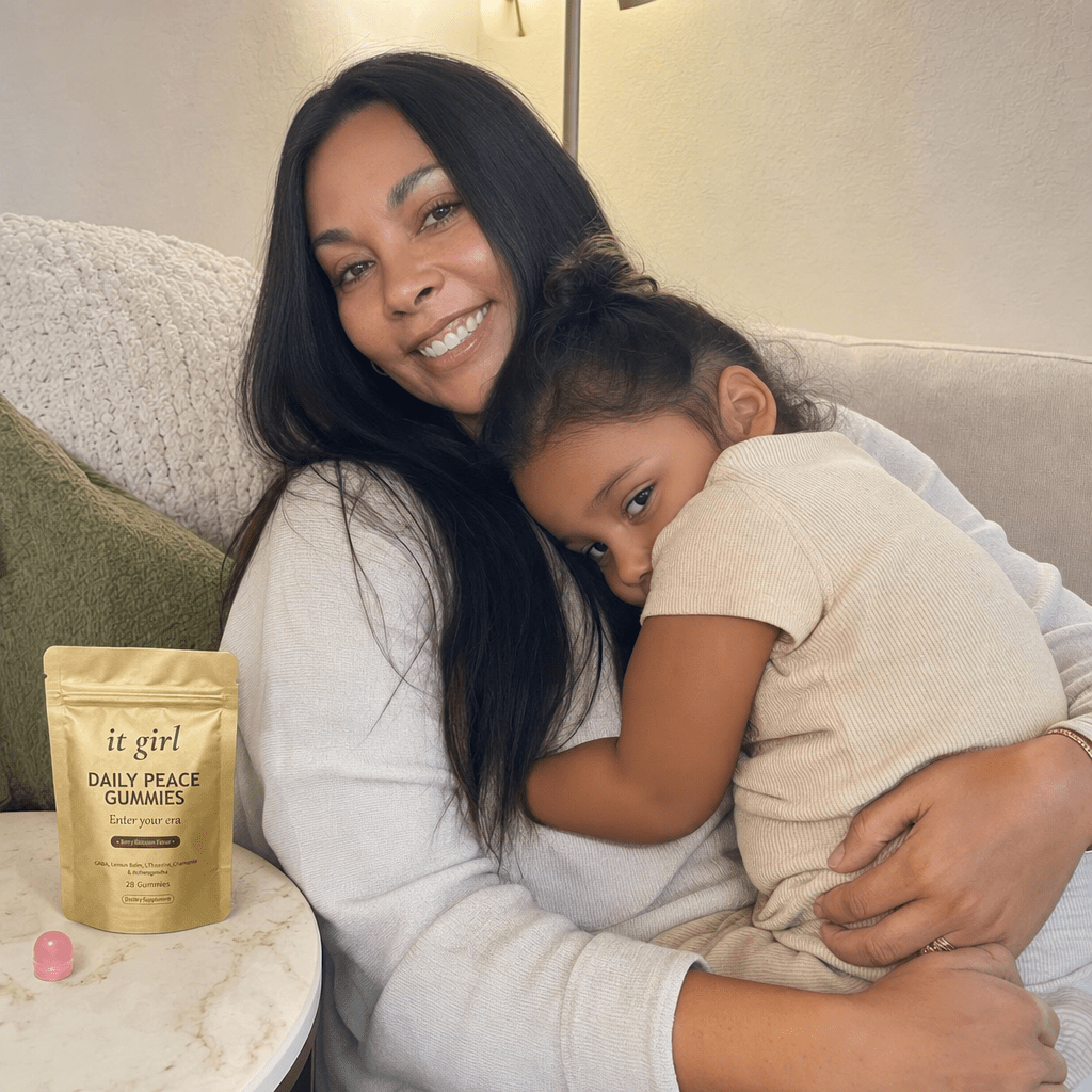 Composed mother carrying real calm as her child climbs calmly back into her lap on the couch, the woman she becomes, pouch subtly with her