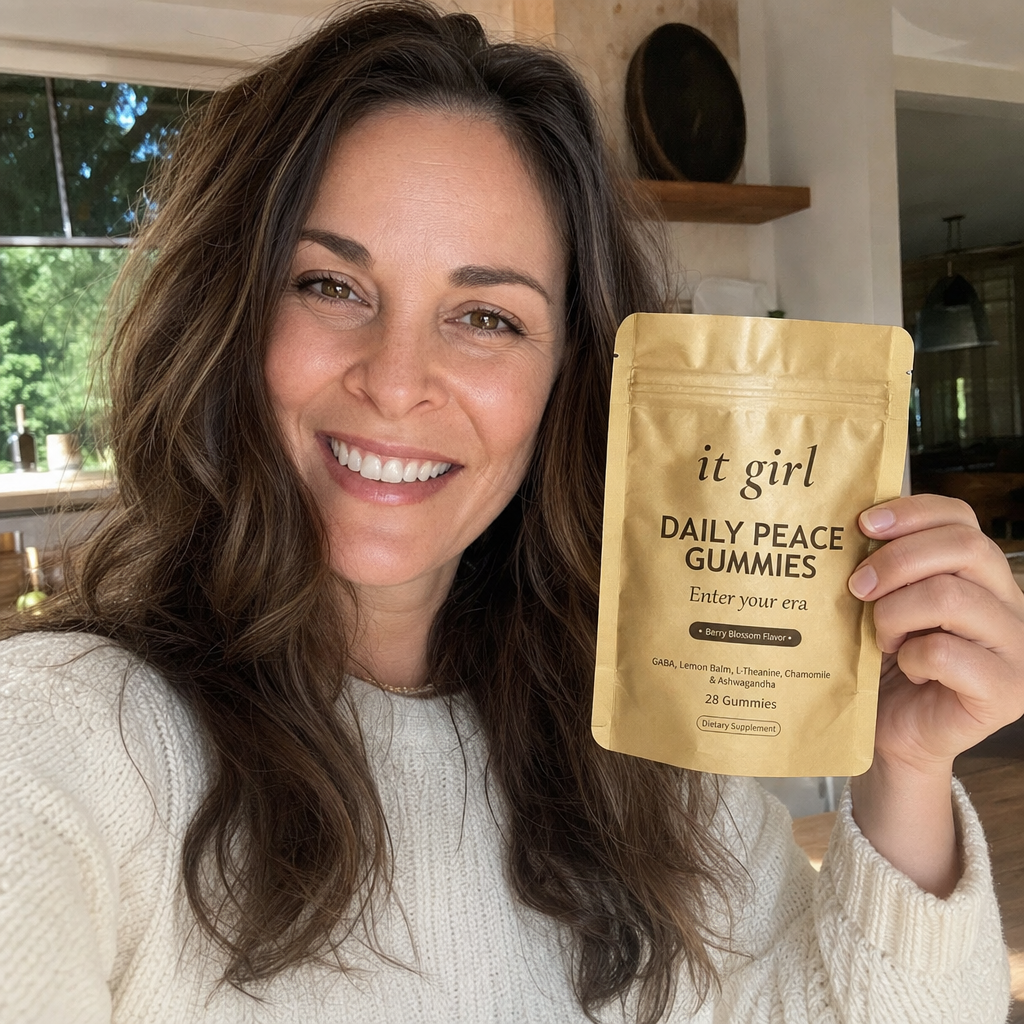 Photoreal selfie of Lauren Hartley smiling and holding the gold It Girl Daily Peace pouch in a sunlit home, the contributor who ran the investigation and partnered with It Girl