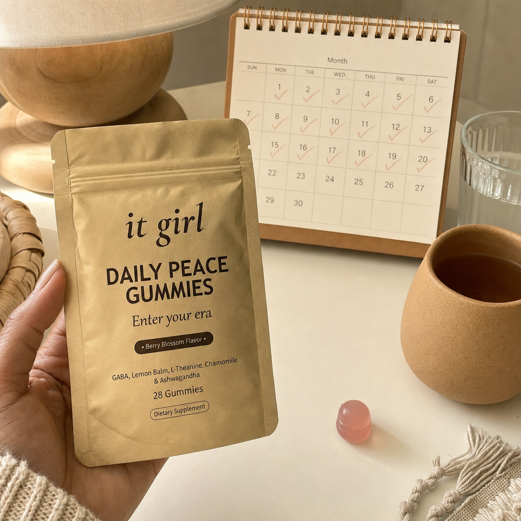 The palm-sized gold Daily Peace pouch beside a month calendar on a cream surface, a whole month of calm for about a dollar a day