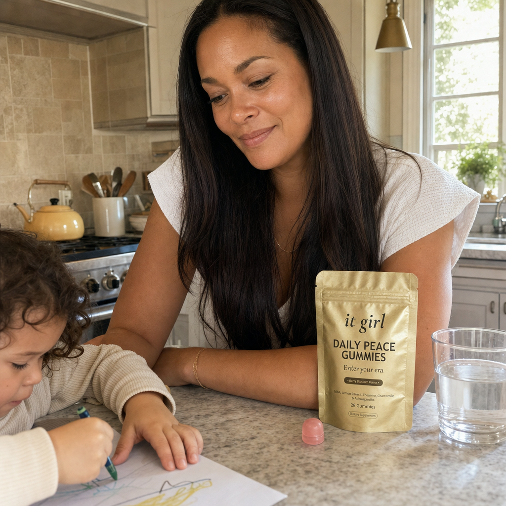 A calm, restored mother about forty steady in her warm afternoon kitchen with her child nearby, the gold Daily Peace pouch on the counter and a glass of water, no wine