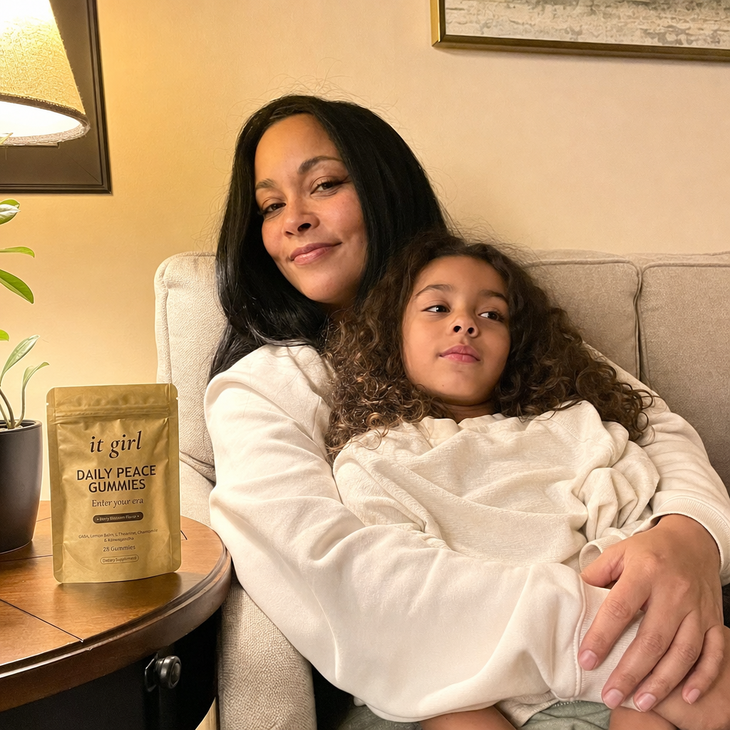 A present mother on the couch in warm lamplight with her nine-year-old climbed into her lap, her phone nowhere in sight, the gold Daily Peace pouch resting on the side table