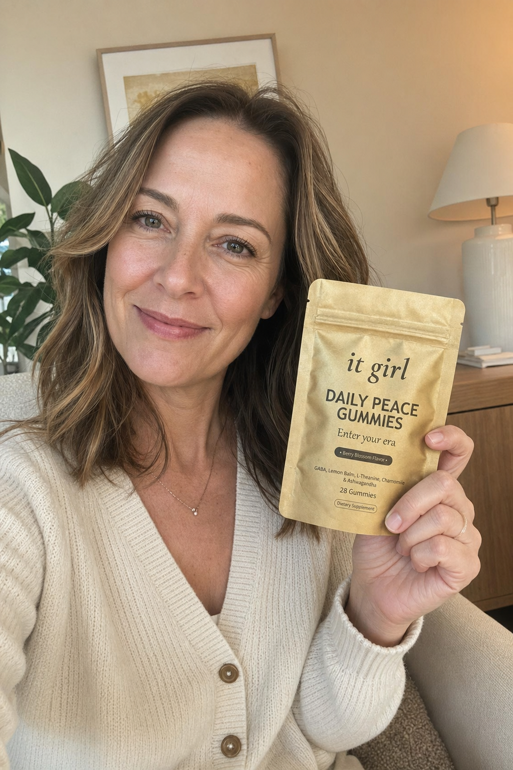 Maya Ellison, a warm licensed therapist in her 40s, holding the real It Girl Daily Peace calm gummies pouch in a soft warm home setting