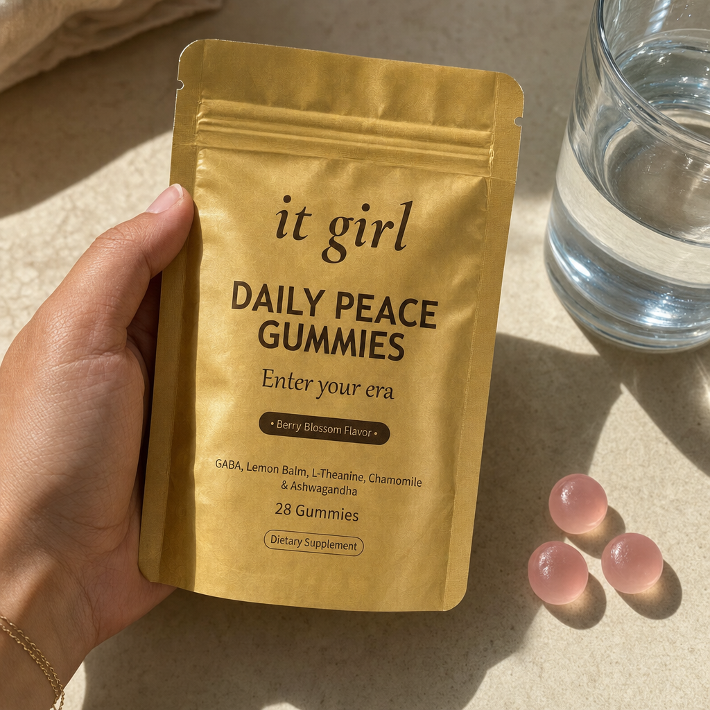 The real It Girl Daily Peace pouch held at palm scale with gummies and water in soft daylight