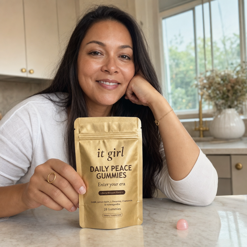 The It Girl Daily Peace pouch on a tidy kitchen counter, a relaxed mom in the warm background