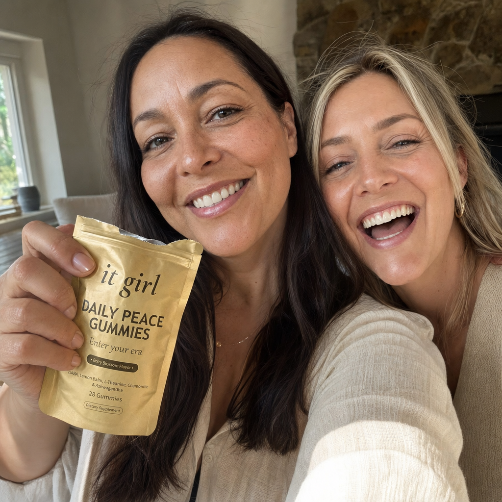 Candid arm's-length selfie of a smiling woman in her forties holding an open gold It Girl Daily Peace pouch up in her hand in a warm sunlit room, a real woman who uses it, not the only one