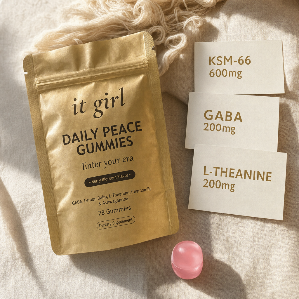 The real matte gold It Girl Daily Peace pouch and a single pink gummy beside three dose cards: KSM-66 600mg, GABA 200mg, L-Theanine 200mg.