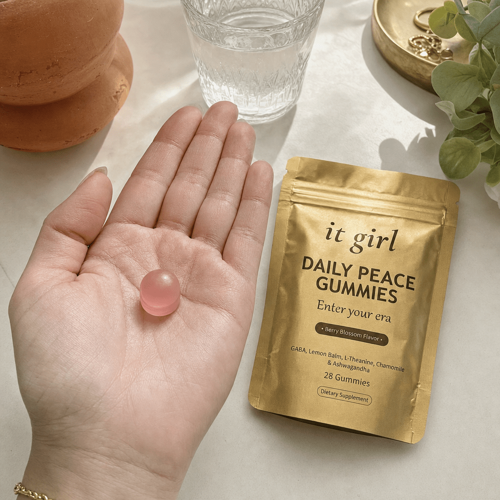 Open palm holding a single pink Daily Peace gummy beside the gold pouch and a glass of water, the GABA and L-Theanine signal