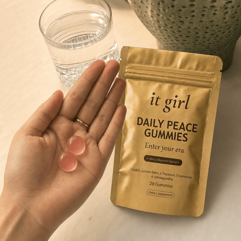 Open palm holding two Daily Peace gummies beside the gold pouch and a glass of water in warm evening light, the GABA plus L-Theanine signal delivered clean
