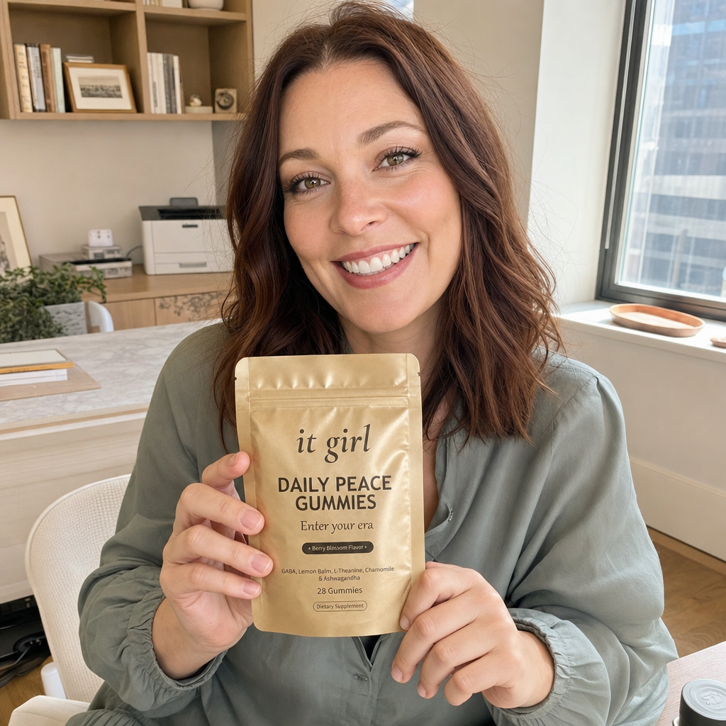 Lauren Hartley smiling and relaxed at her office desk holding the It Girl Daily Peace pouch, recommending the formula she trusted enough to partner with