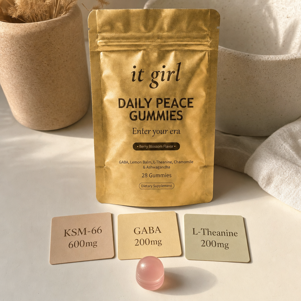 Three warm dose cards reading KSM-66 600mg, GABA 200mg, L-Theanine 200mg beside a single gummy and the gold Daily Peace pouch on a cream surface, two layers in one gummy