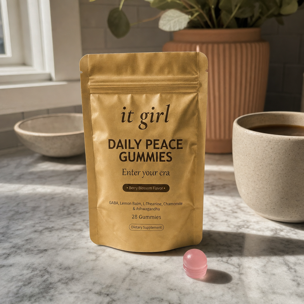 The real palm-sized gold It Girl Daily Peace pouch on a kitchen counter in calm warm morning light, a 28-day-supply one-for-every-night feel, no clutter