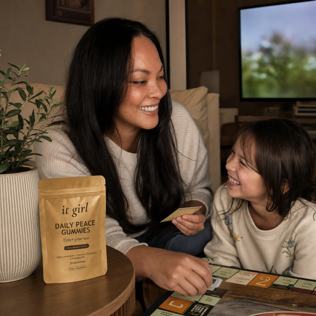 A mom genuinely present and laughing with her family on the couch during game night, the real It Girl Daily Peace pouch resting on a side table