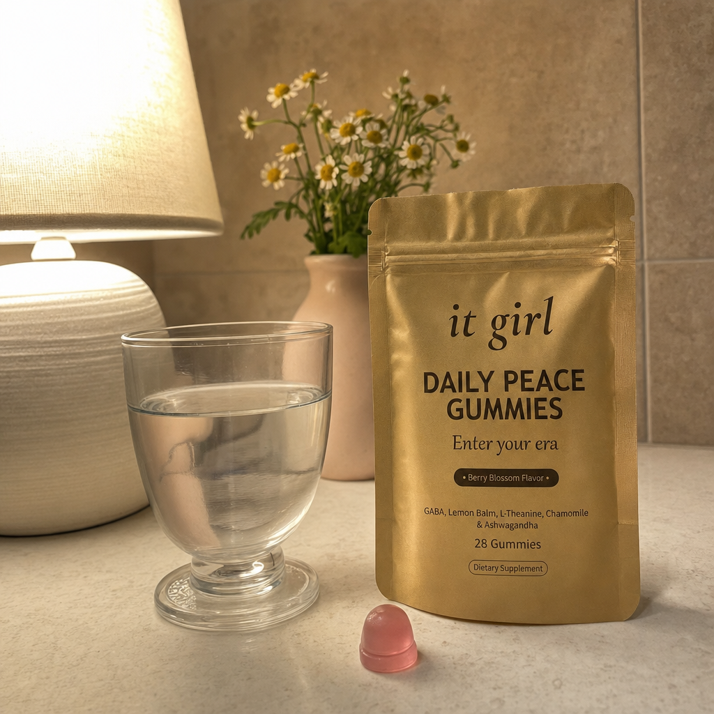 A warm early-evening kitchen counter at the moment the wound-up feeling hits, a glass of water and the real It Girl Daily Peace pouch by a softly glowing lamp