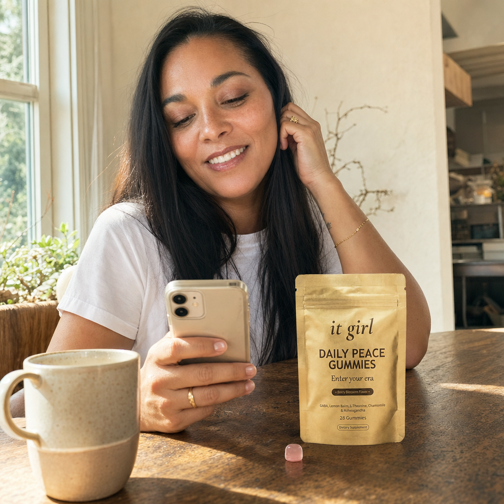 A woman in her forties taking her calm five-minute break with the It Girl app open on her phone and the gold Daily Peace pouch resting beside her