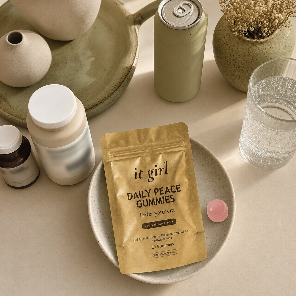 Cream counter of the abandoned swaps, an alcohol-free wine bottle, an adaptogen drink can, a magnesium bottle and a melatonin bottle pushed aside, the gold Daily Peace pouch chosen forward, no people