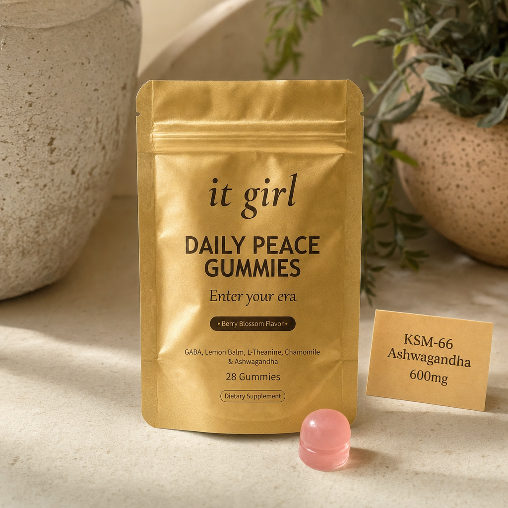 Three warm dose cards reading KSM-66 600mg, GABA 200mg, L-Theanine 200mg beside a single pink gummy and the gold Daily Peace pouch on a cream surface, the named studied dose