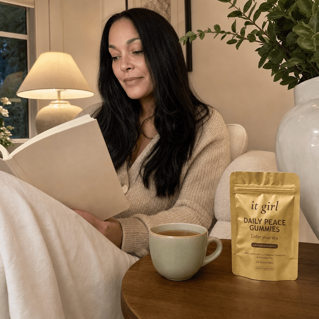 Woman 40 to 52 awake and at ease in her living room in early evening with herbal tea, a gold Daily Peace pouch resting subtly on the side table, calm without sedation