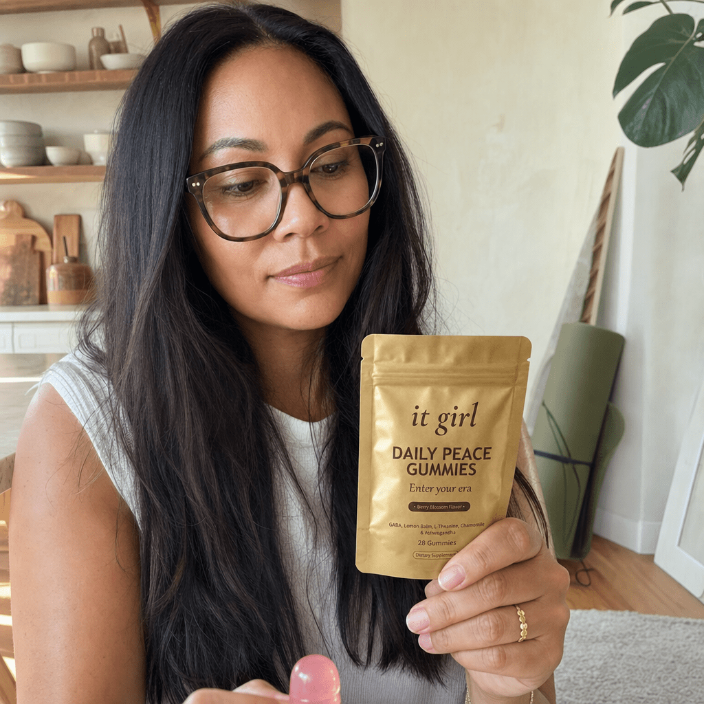 Woman 32 to 45 turning a gold Daily Peace pouch over to read the ingredient panel, glasses on, the woman who finally got the right frame