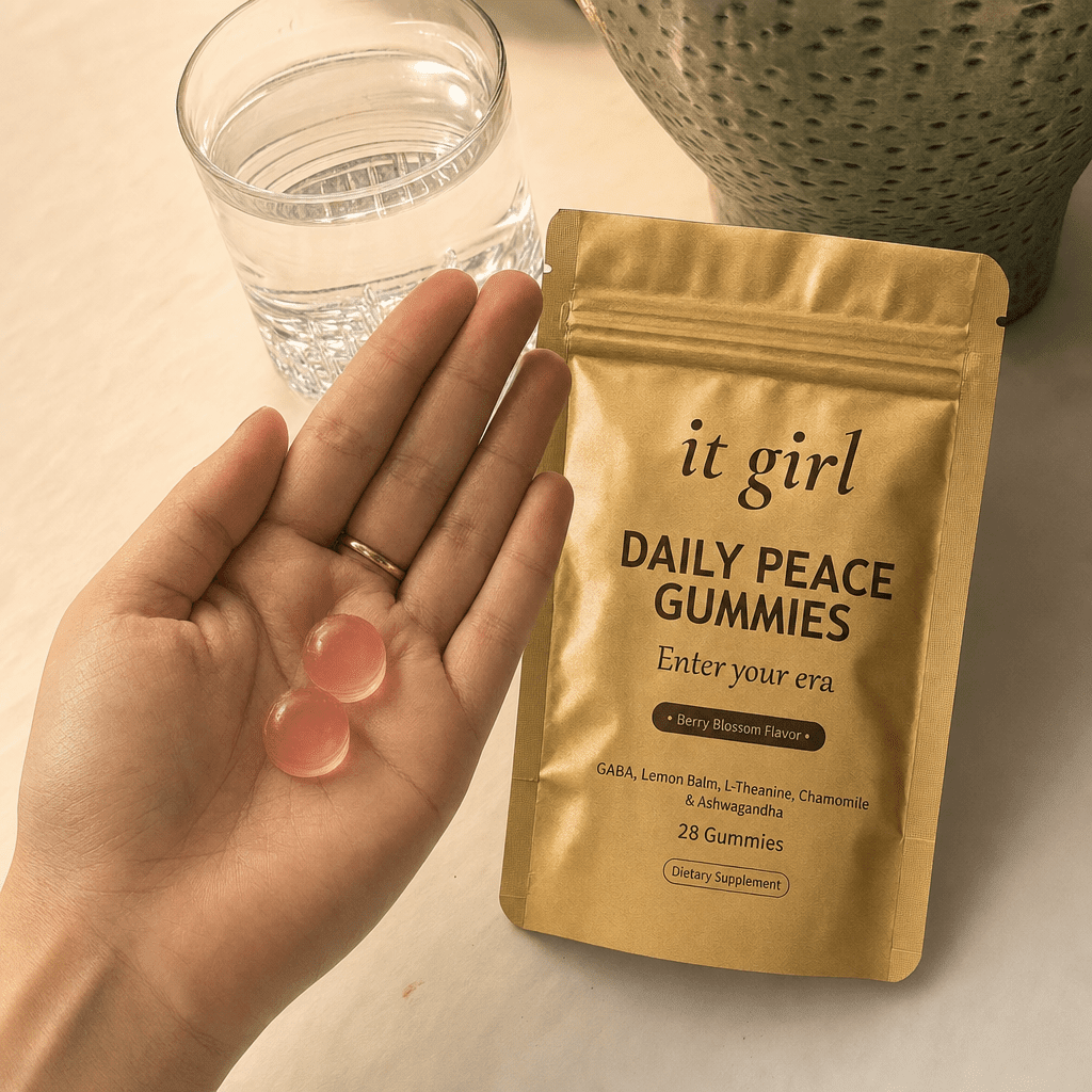 Open palm holding two Daily Peace gummies beside the gold pouch and a glass of water in warm evening light, the GABA plus L-Theanine signal delivered clean