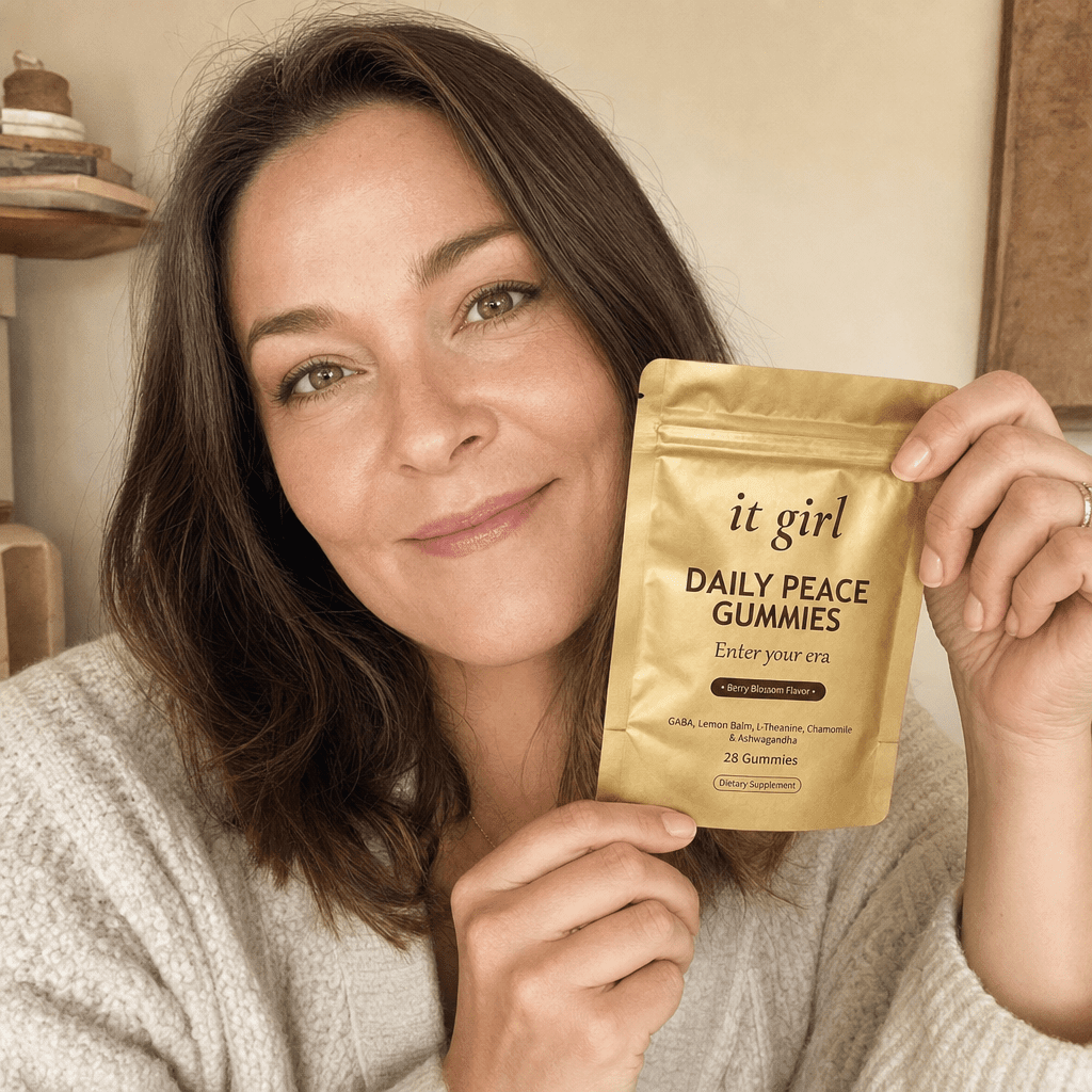 Lauren Hartley holding the gold It Girl Daily Peace pouch up beside her face with a warm smile, the author behind the product she partnered with