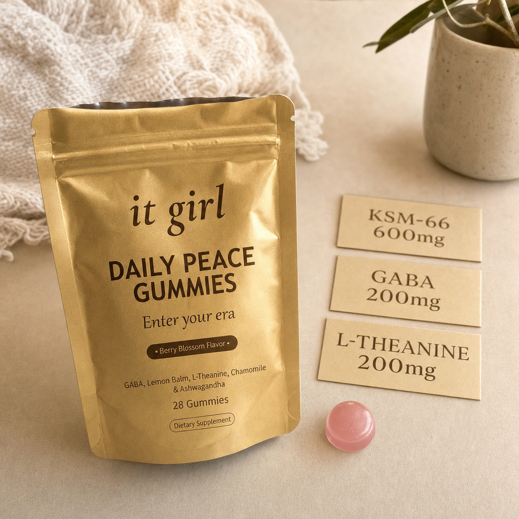The real matte gold It Girl Daily Peace pouch and a single pink gummy beside three dose cards: KSM-66 600mg, GABA 200mg, L-Theanine 200mg.
