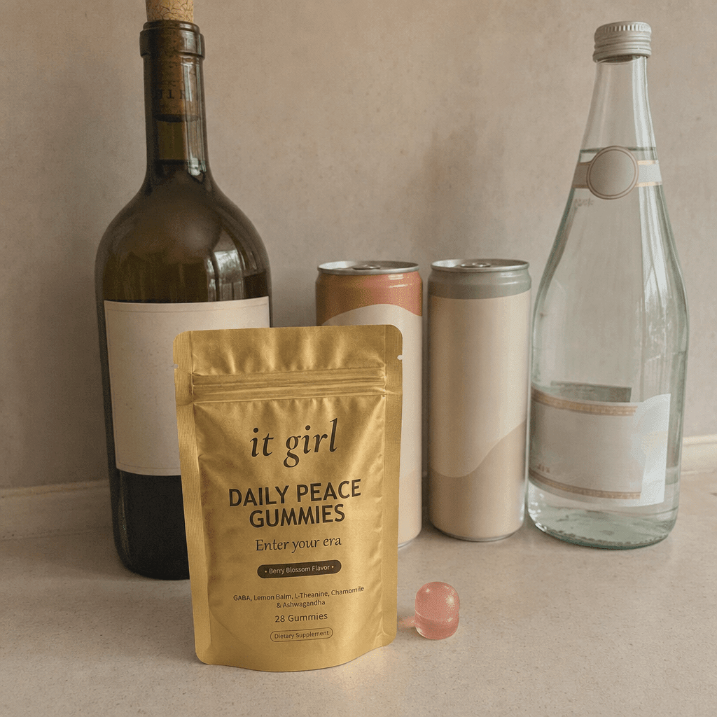 The real It Girl Daily Peace pouch on a warm cream counter beside the untouched wine alternatives, a corked alcohol-free wine bottle and two adaptogen cans, the one that finally goes after the signal instead of the glass