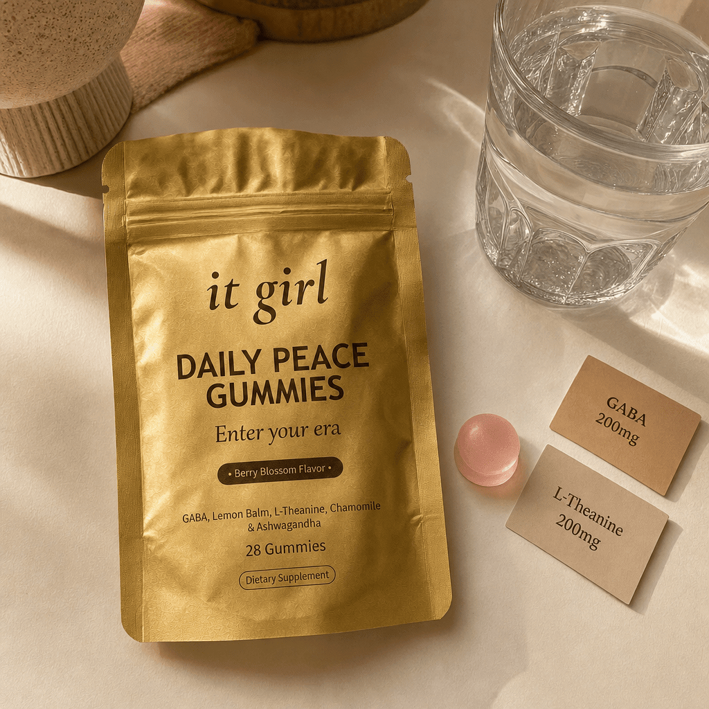 The real It Girl Daily Peace pouch laid open with one pink gummy beside it and two warm dose cards reading GABA 200mg and L-Theanine 200mg on a cream surface in soft evening light