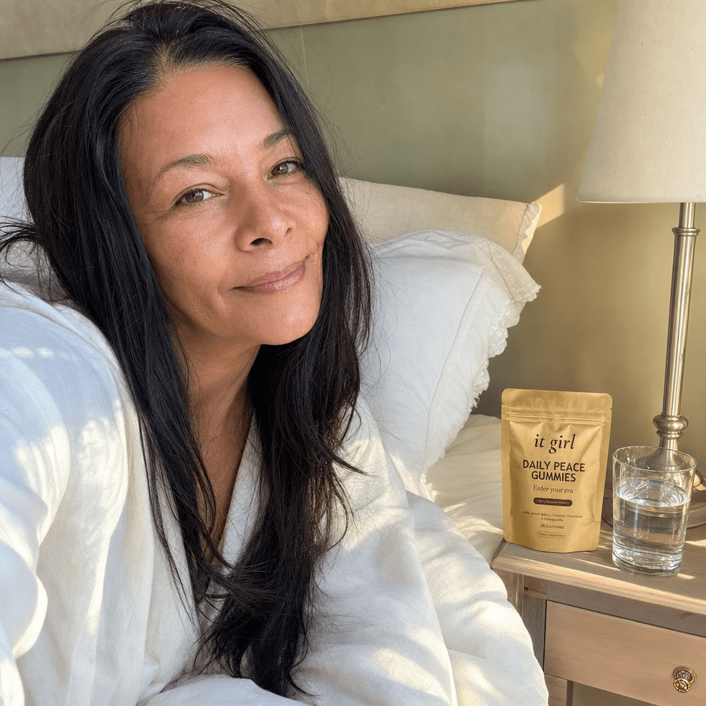 A woman waking clear and rested in soft morning light with the gold Daily Peace pouch on her nightstand, no foggy wine morning