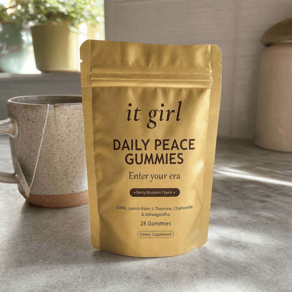 The real palm-sized gold It Girl Daily Peace pouch standing on a clean kitchen counter in soft warm morning light, the one-for-every-night calm-morning feel, no clutter