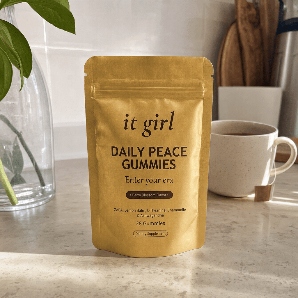 The real palm-sized gold It Girl Daily Peace pouch standing on a clean kitchen counter in soft warm morning light, the one-for-every-night calm-morning feel, no clutter