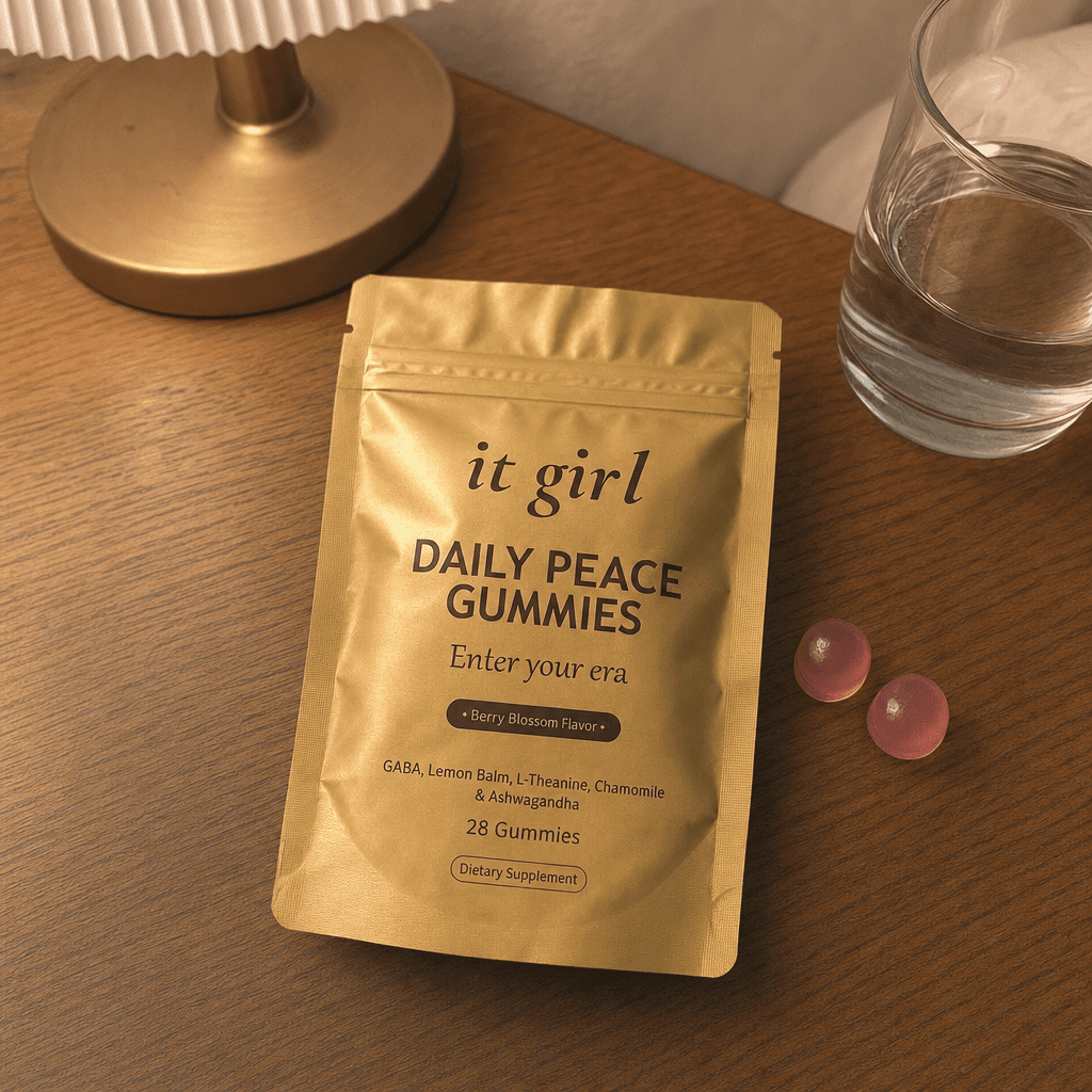 The real gold It Girl Daily Peace pouch opened on a warm evening nightstand beside a calm berry-blossom gummy and a glass of water, the drained calm signal handed back