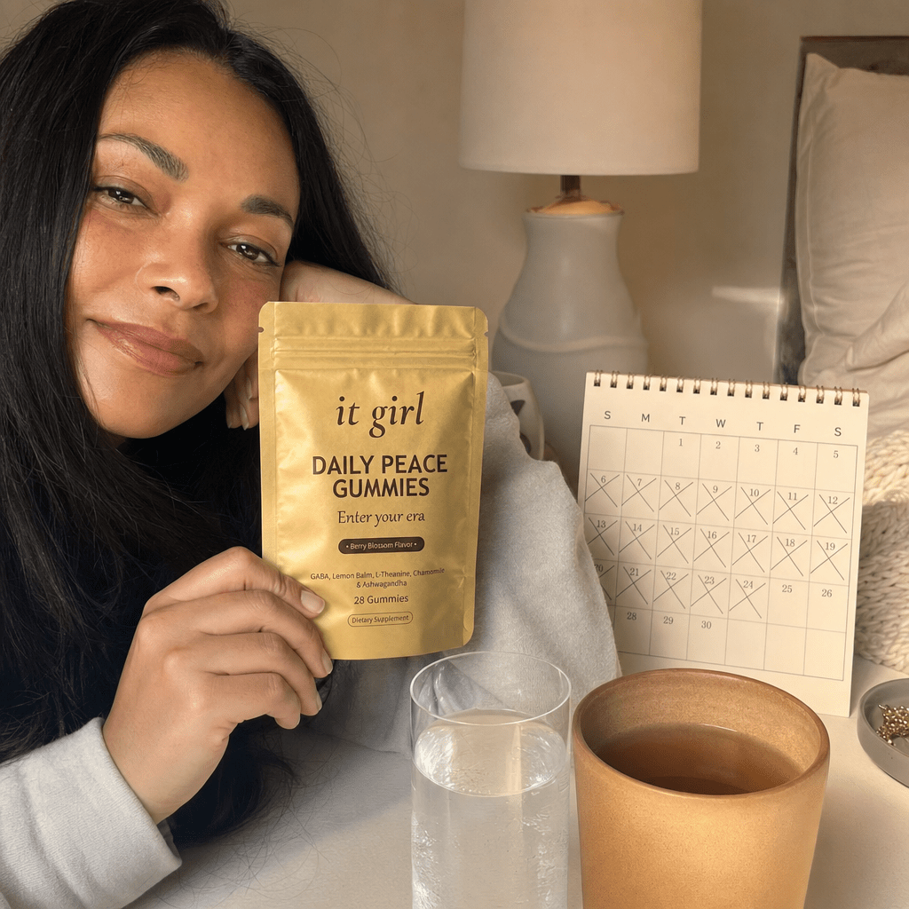 The palm-sized gold Daily Peace pouch beside a month calendar on a cream surface, a whole month of calm for about a dollar a day