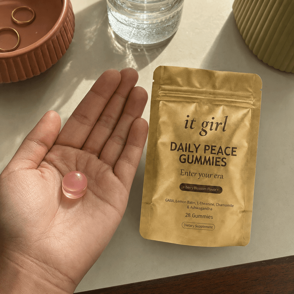 Open palm holding a single pink Daily Peace gummy beside the gold pouch and a glass of water, the GABA and L-Theanine signal