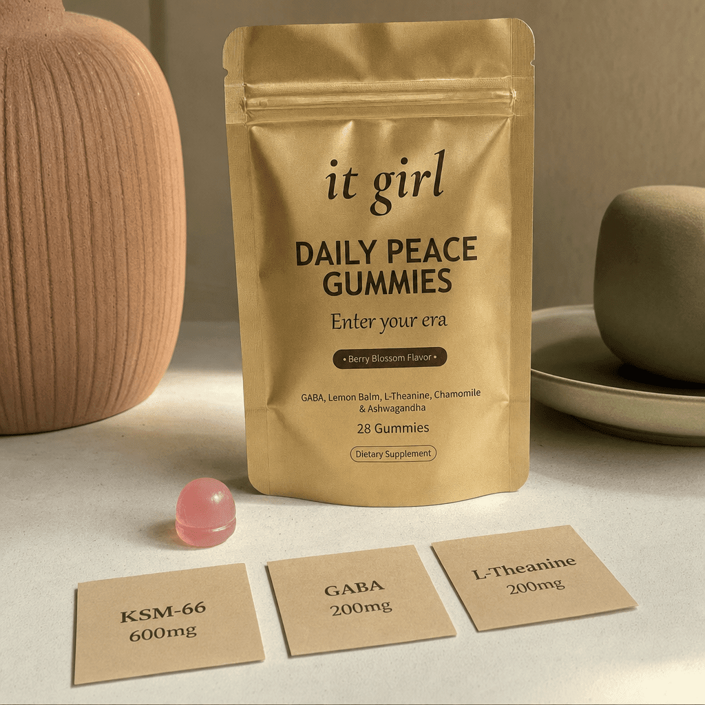 Three warm dose cards reading KSM-66 600mg, GABA 200mg, L-Theanine 200mg beside a single gummy and the gold Daily Peace pouch on a cream surface, two layers in one gummy