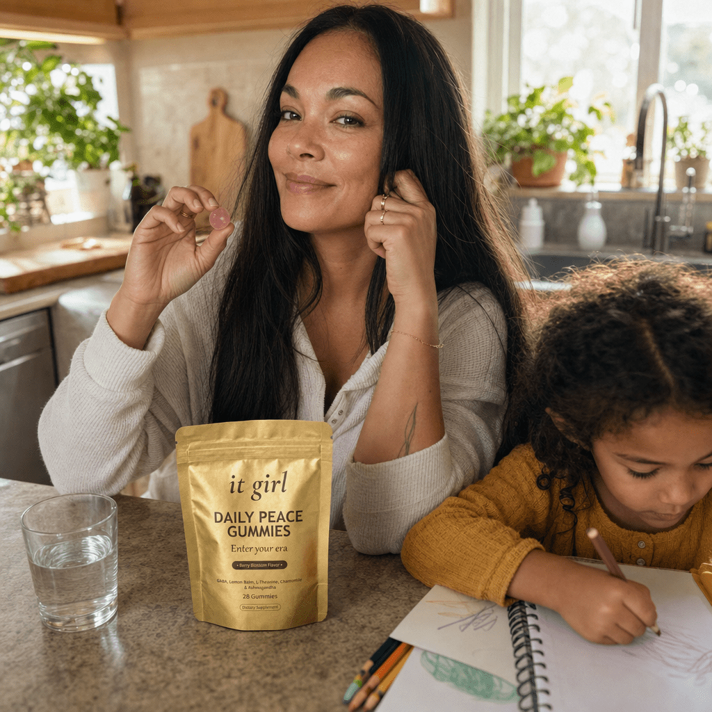 A calm, restored mother about forty steady in her warm afternoon kitchen with her child nearby, the gold Daily Peace pouch on the counter and a glass of water, no wine