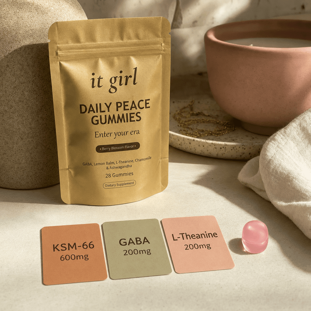 Three warm dose cards reading KSM-66 600mg, GABA 200mg, L-Theanine 200mg beside a single gummy and the gold Daily Peace pouch on a cream surface, two layers in one gummy