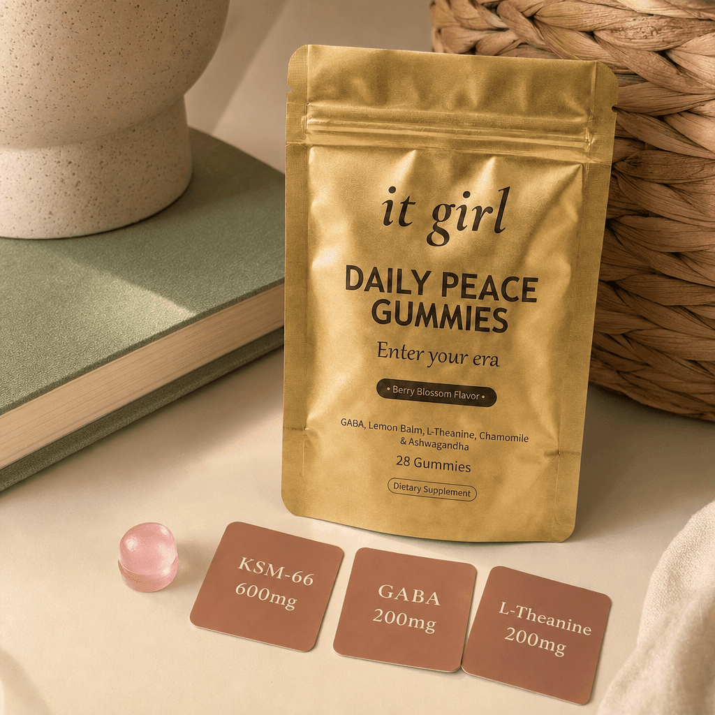 Three warm dose cards reading KSM-66 600mg, GABA 200mg, L-Theanine 200mg beside a single gummy and the gold Daily Peace pouch on a cream surface, two layers in one gummy