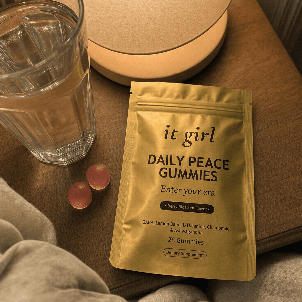 The real gold It Girl Daily Peace pouch opened on a warm evening nightstand beside a calm berry-blossom gummy and a glass of water, the drained calm signal handed back