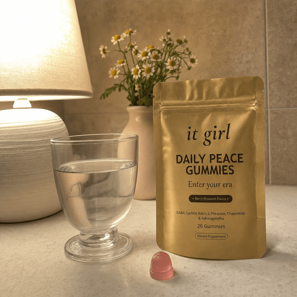 A warm early-evening kitchen counter at the moment the wound-up feeling hits, a glass of water and the real It Girl Daily Peace pouch by a softly glowing lamp