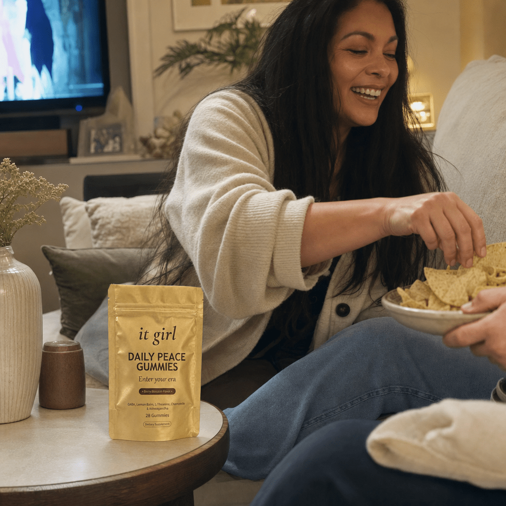 Cristina relaxed and present on the couch on game night, shoulders down and stealing a chip off her husband's plate, the real It Girl Daily Peace pouch on the side table