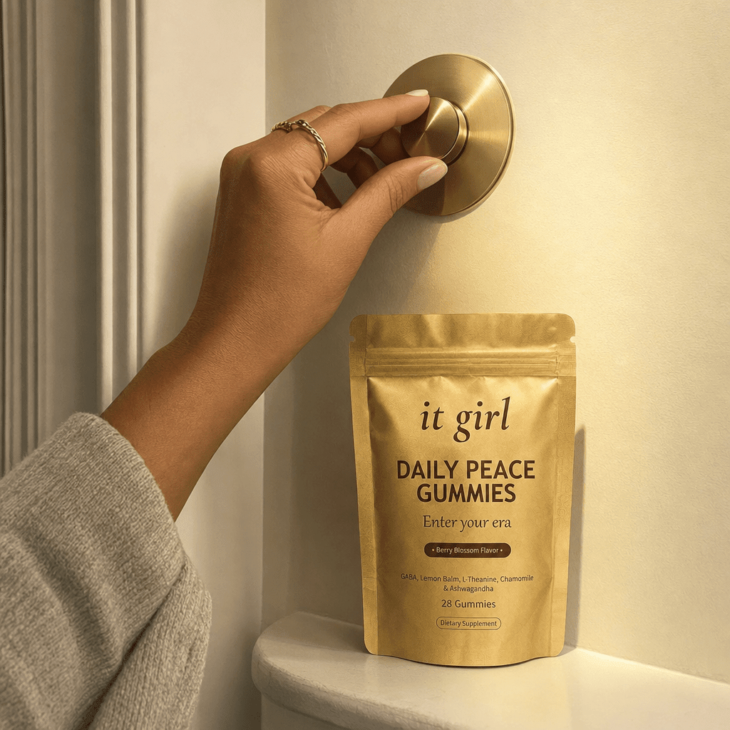 A hand gently turning a warm brass dimmer dial so a soft golden light grows brighter, the gold It Girl Daily Peace pouch on a ledge beneath it, the calm signal coming back online