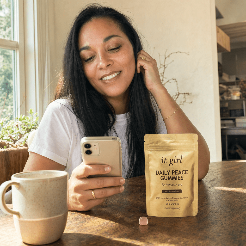A woman in her forties taking her calm five-minute break with the It Girl app open on her phone and the gold Daily Peace pouch resting beside her