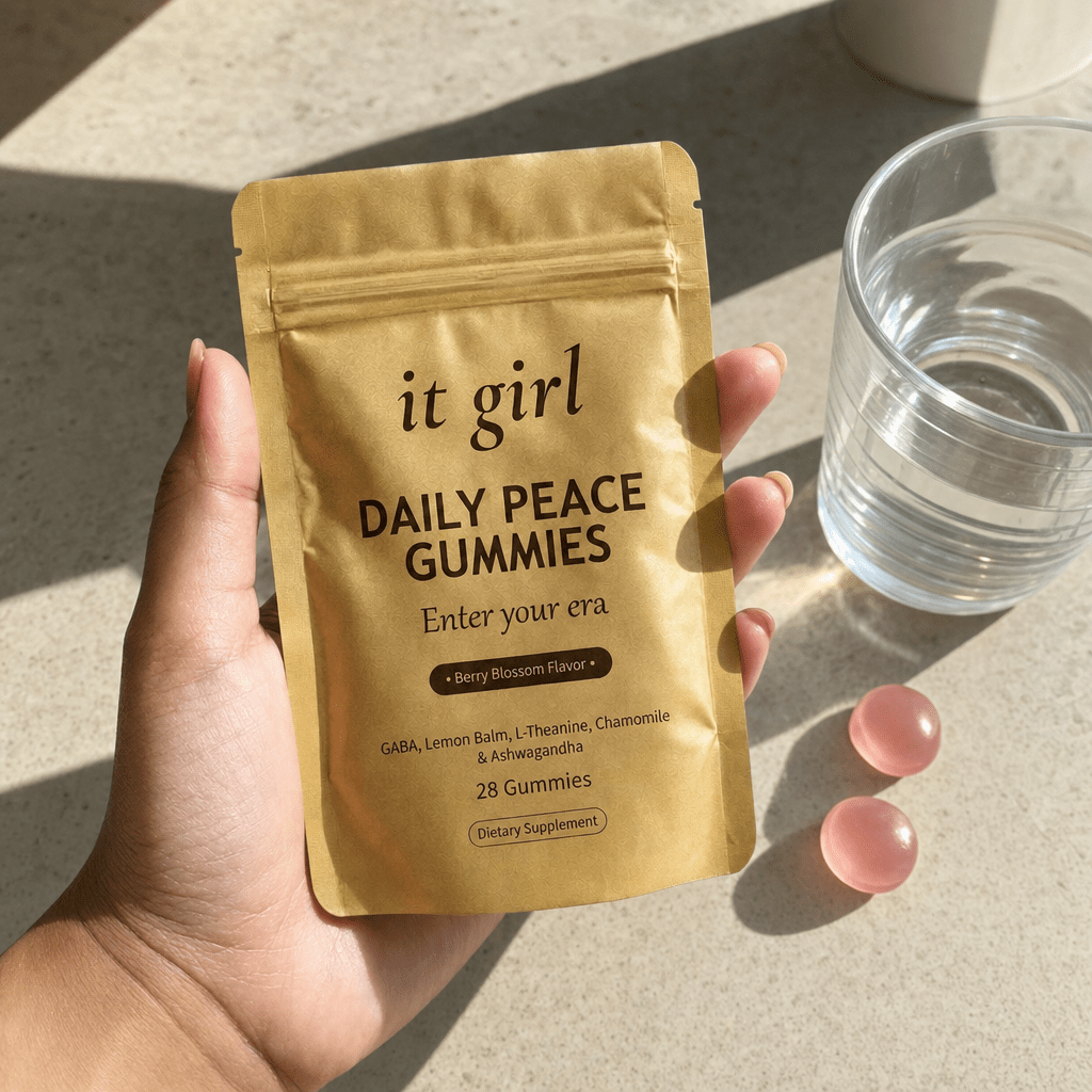 The real It Girl Daily Peace pouch held at palm scale with gummies and water in soft daylight