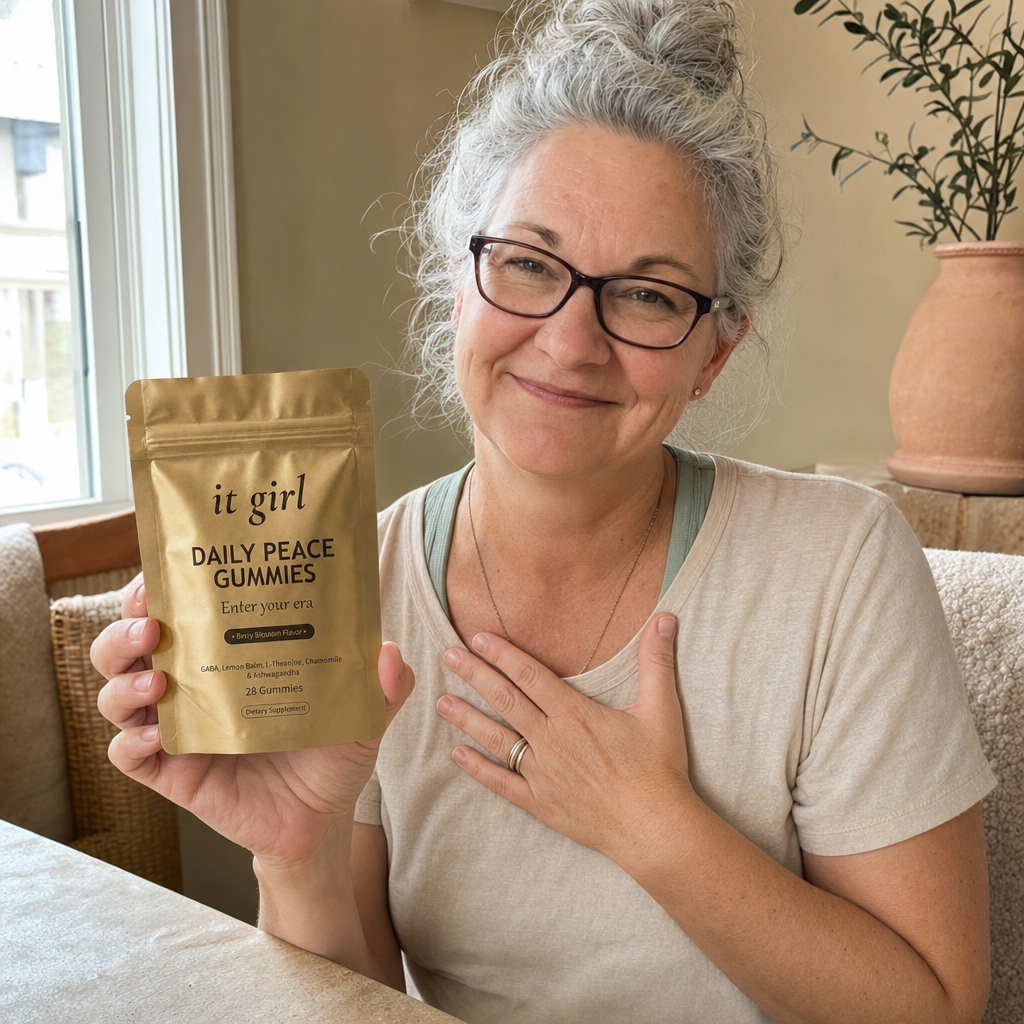 The same woman in a quiet moment of self-forgiveness, one hand resting over her heart in soft morning light, years of self-blame lifting, the gold Daily Peace pouch nearby