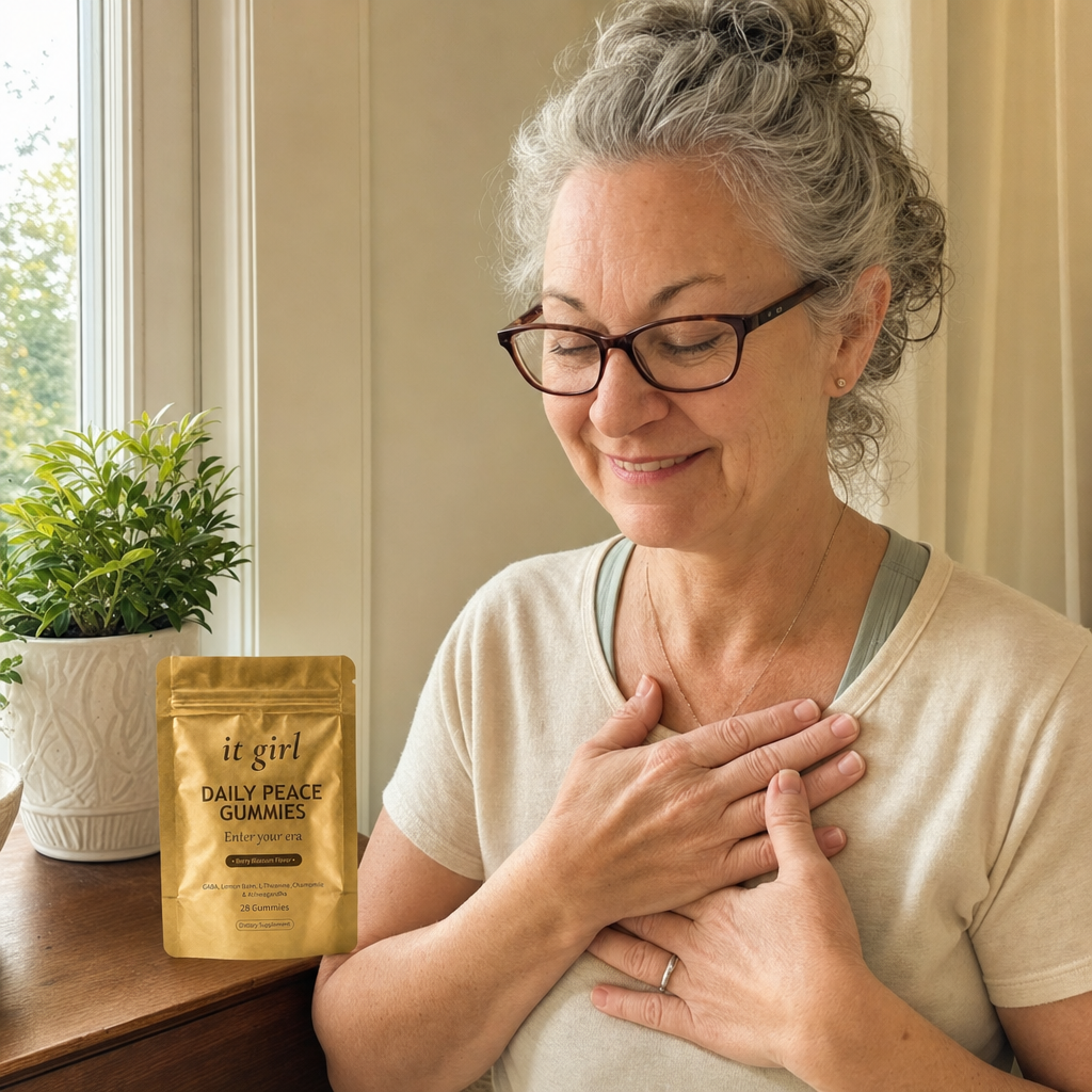 Woman about sixty at a window, hand resting on her chest, self-compassionate, the gold Daily Peace pouch resting nearby, she stopped blaming herself