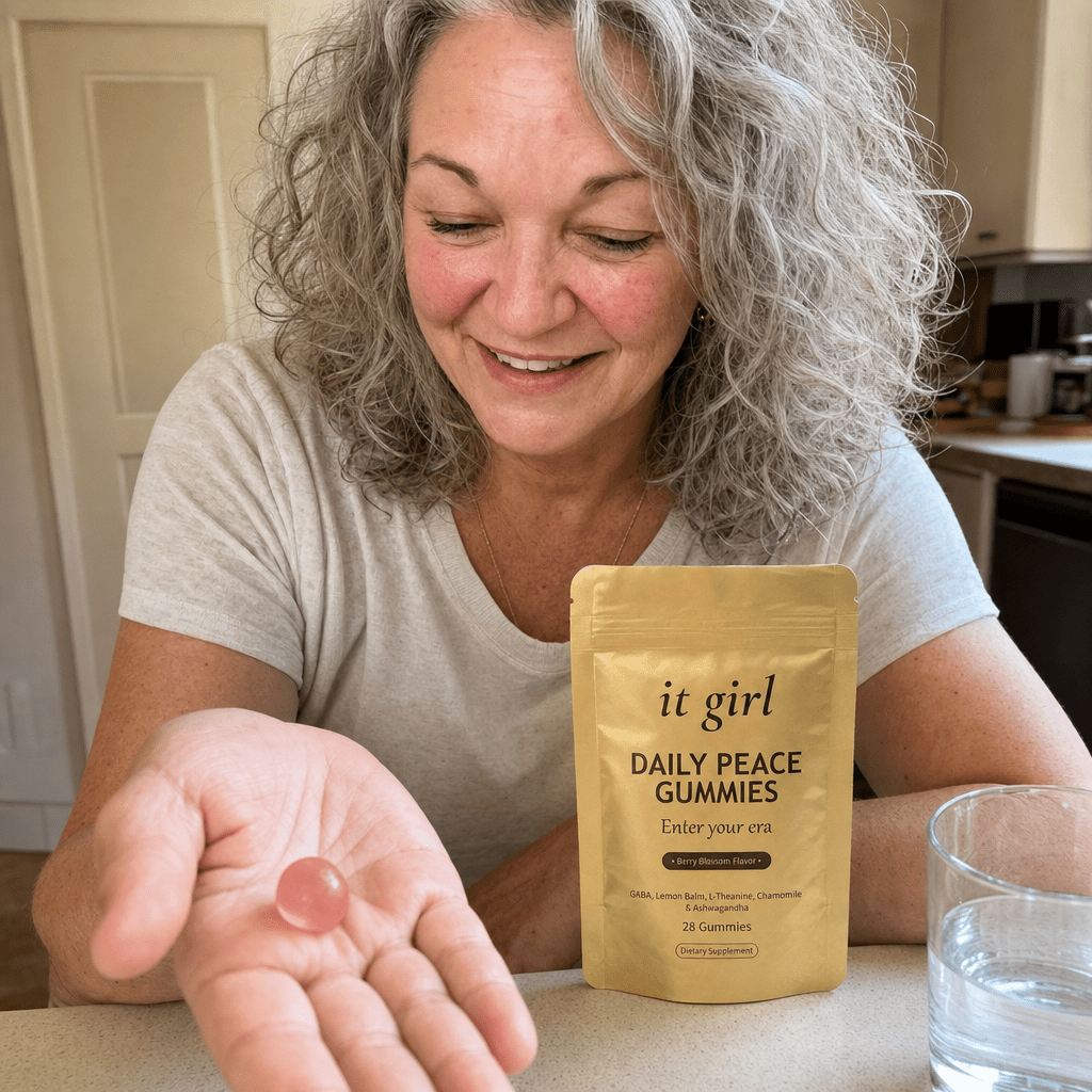 Cristina's open palm holding a single pink Daily Peace gummy beside the gold pouch and a glass of water, the GABA and L-Theanine calm signal