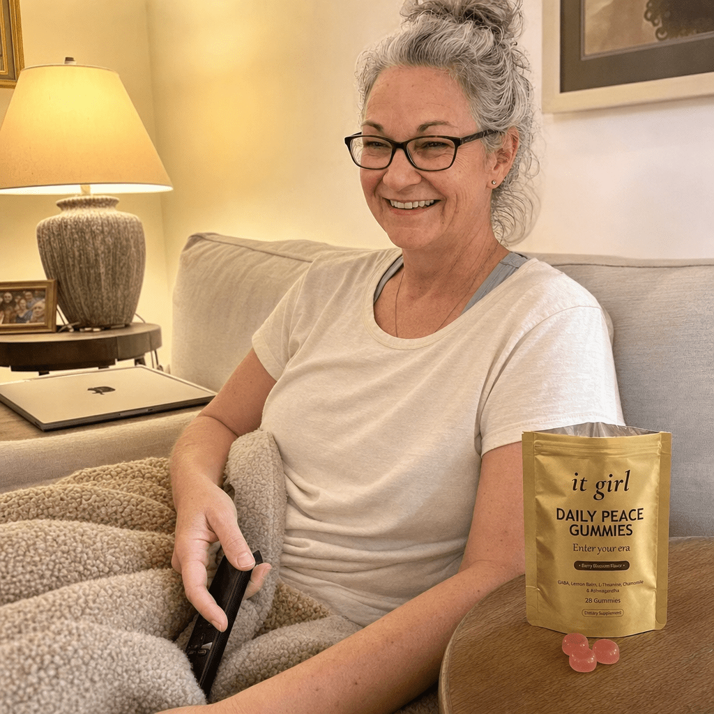 Cristina calm on her couch in the evening with the laptop closed and an open It Girl Daily Peace pouch nearby, watching instead of reaching, no wine glass