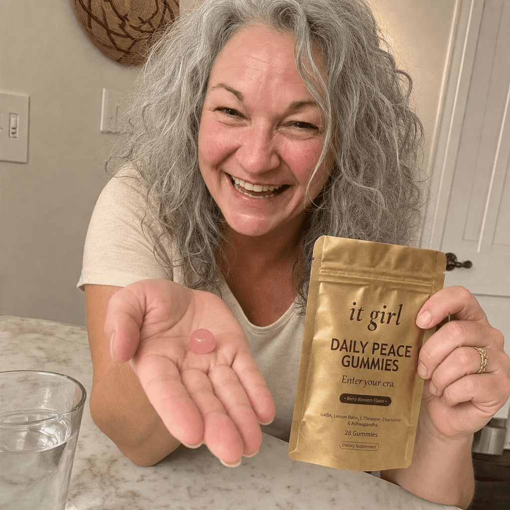 Cristina's open palm holding a single pink Daily Peace gummy beside the gold pouch and a glass of water, the GABA and L-Theanine calm signal